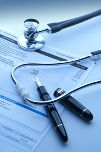 stethoscope with a pen on top of a medical bill